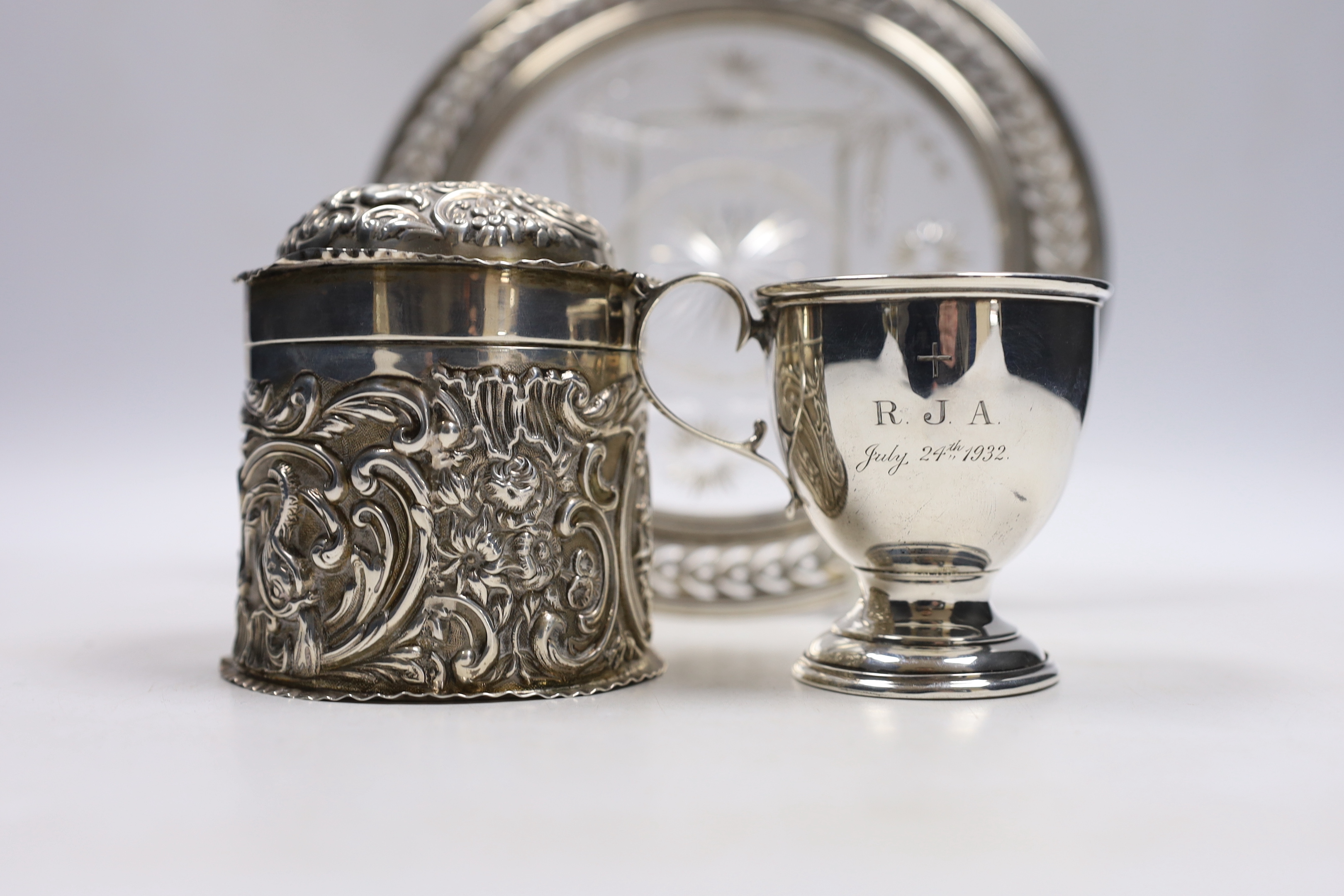 A late Victorian repousse silver cannister and cover, by William Comyns, London, 1896, 92mm a sterling mounted glass stand and a small silver cup.